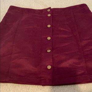 Velvet skirt with gold buttons down it.